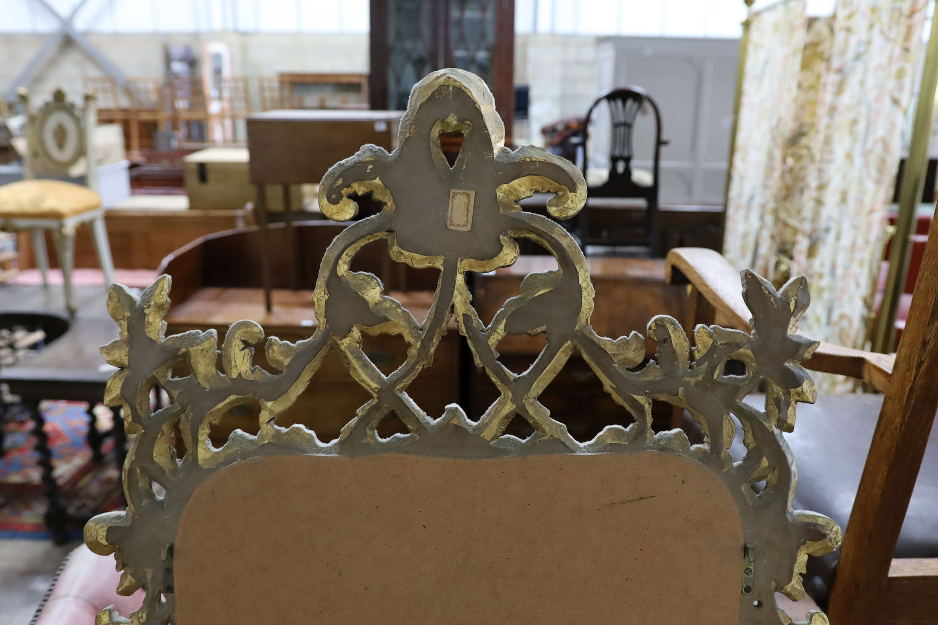 An 18th century style carved giltwood scrollwork mirror, width 64cm, height 132cm